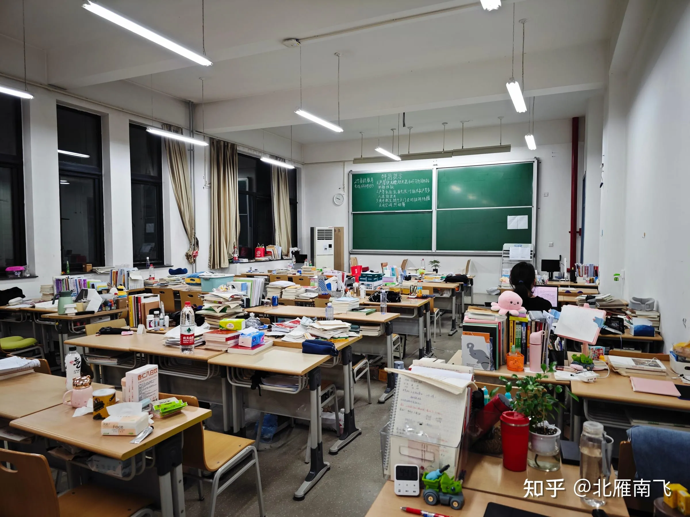 堆满书本的自习室,桌上摆着台灯和小盆栽